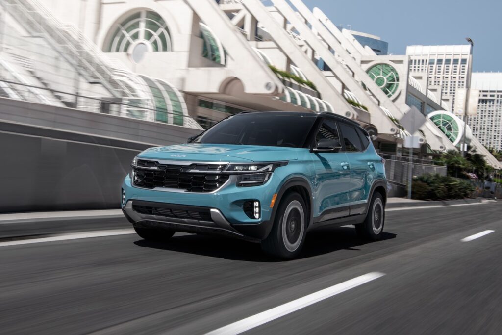 Kia Saltos speeds pass the San Diego convention center three-quarter front view in modern blue color
