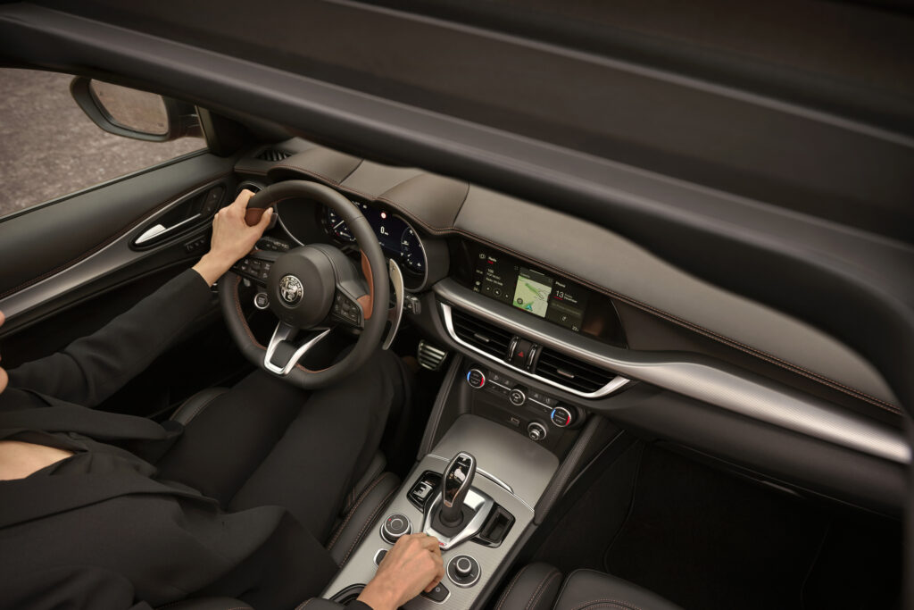 Interior 2025 Alfa Romeo Stelvio with drivers hand on the shifter and the steering wheel