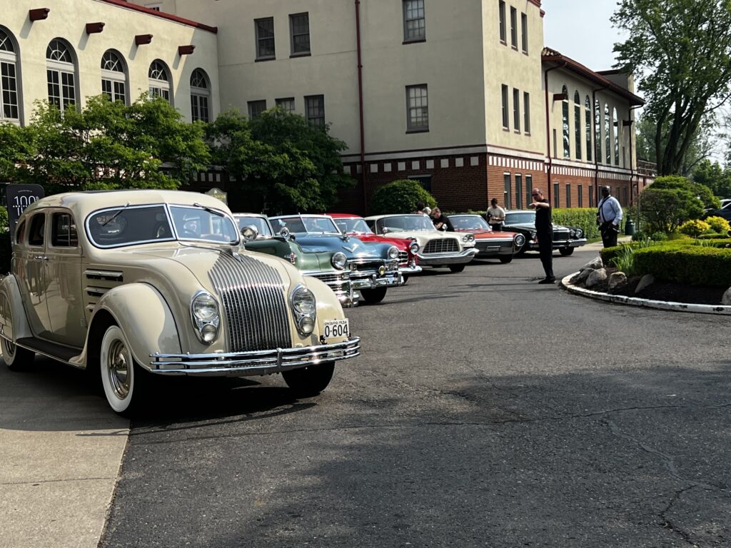A lineup of Chrysler Heritage vehicles from the last hundred years at the Detroit yacht club