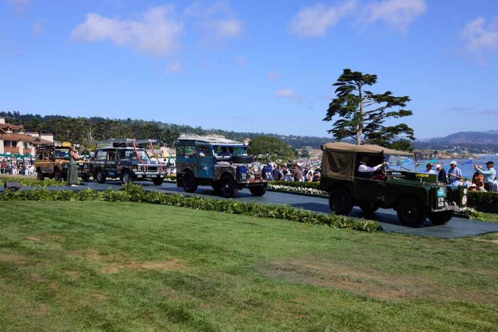 Historic Land Rover vehicles drive onto the lawn at Pebble Beach 2025