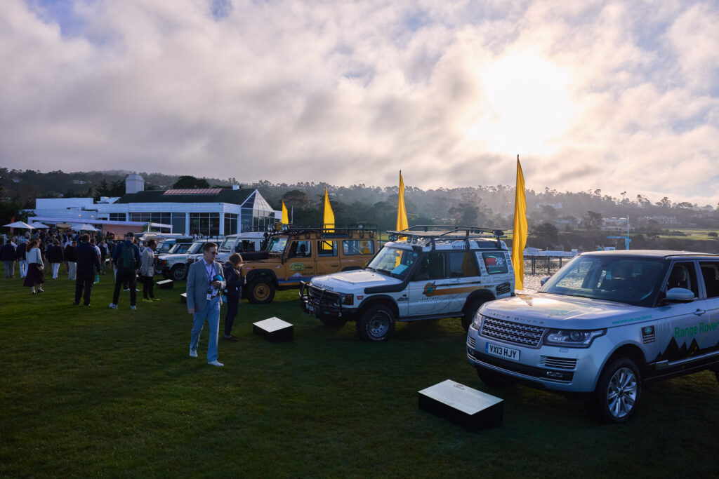 The crowds look on to be historic collection of expedition vehicles on the lawn at Pebble Beach 2025