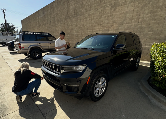 People looking over a car being traded in