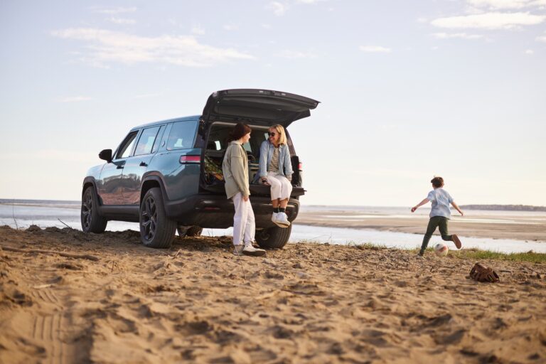 Family on the beach with a Rivian R1 S