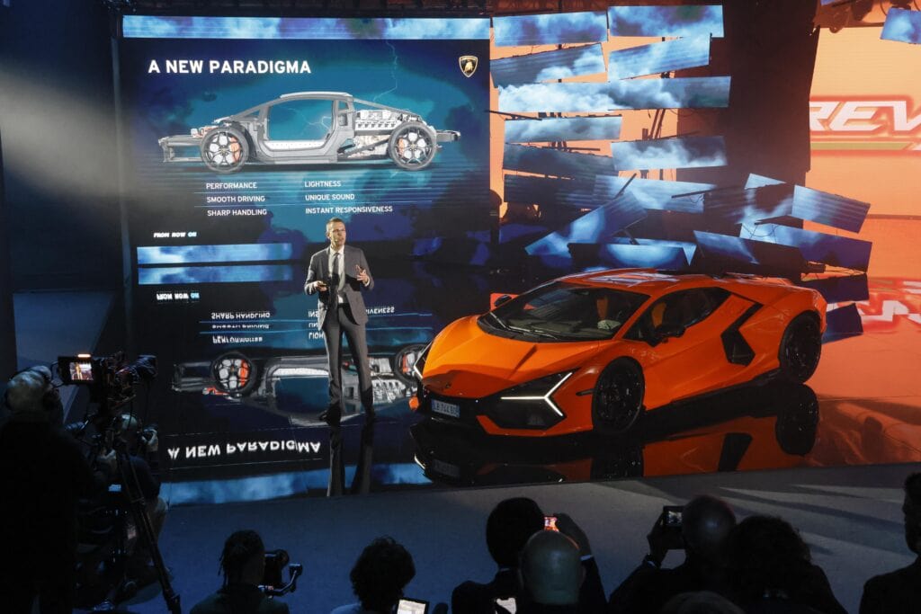 Man speaking at a Lamborghini press conference.