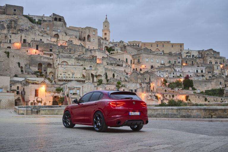 2025 Alfa Romeo Stelvio in front of Italian city in the twilight