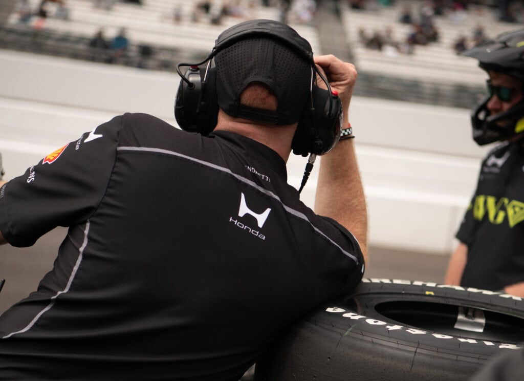 A Honda crew member resting on a tire during Final Practice of the Indy 500