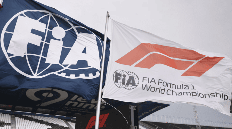 FIA and F1 flag flying next to each other signifying the partnership between the two organizations.