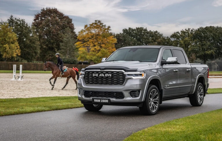 2025 RAM Pickup Truck parked on a road near a person riding a horse
